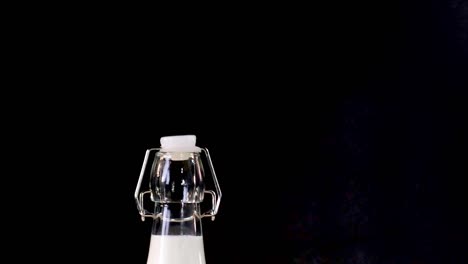 A variety of dairy bottles and cheese wedges arranged on a dark background.