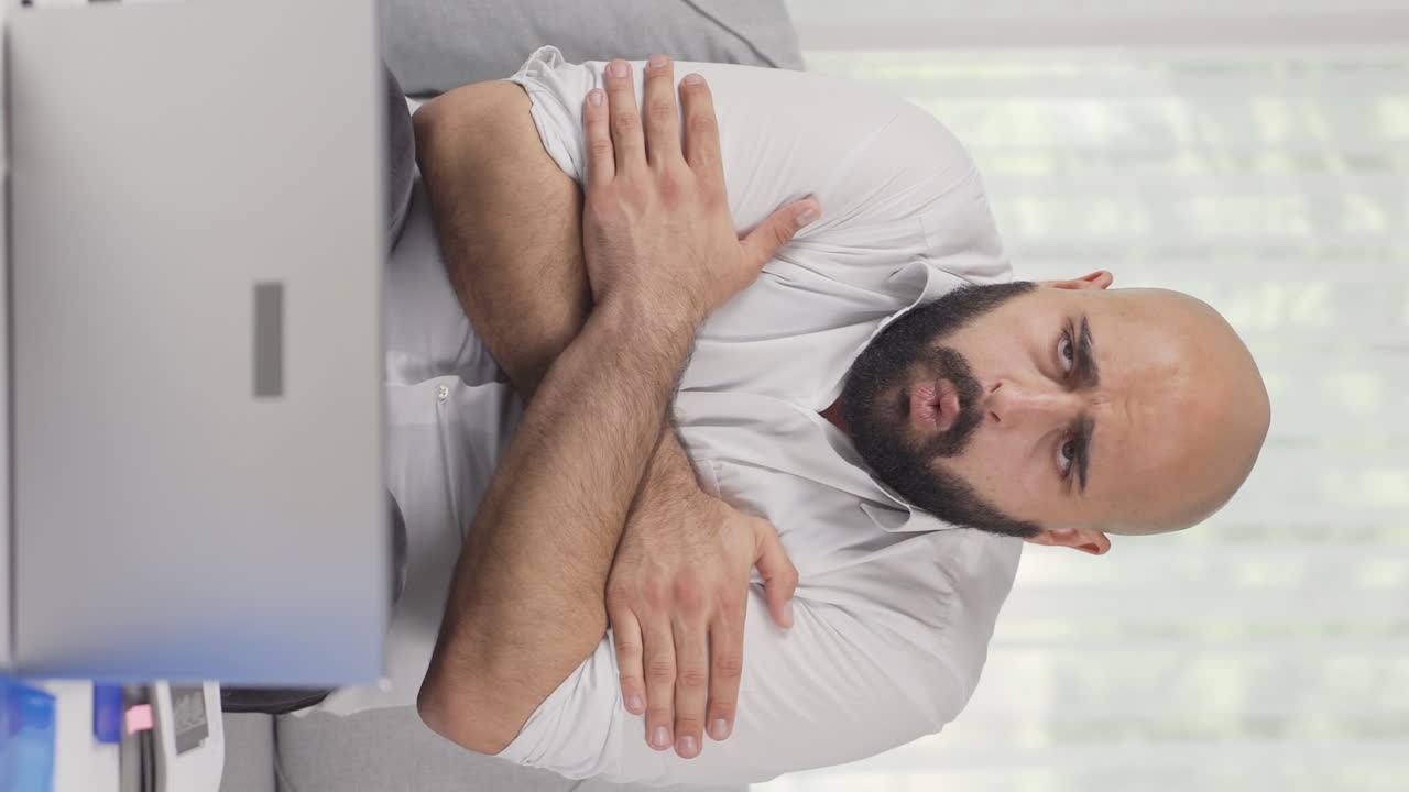 vídeo vertical de un trabajador de oficina en casa con frío, sintiendo frío.