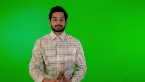 guy-using-mobile---tablet-with-green-screen-and-green-background-indian-guy-with-green-screen