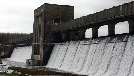 Llyn-Cefni-reservoir-concrete-dam-gate-pouring-from-Llangefni-lagoon,-Anglesey-rural-scene