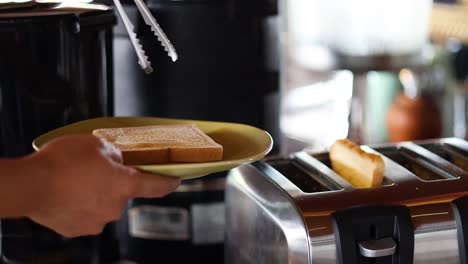 person toasting bread with tongs and toaster