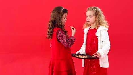 hermanas bonitas y festivas comiendo galletas de navidad
