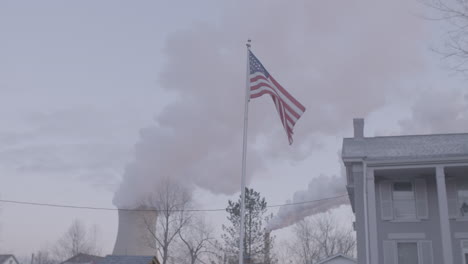 bandera estadounidense en primer plano, chimenea detrás