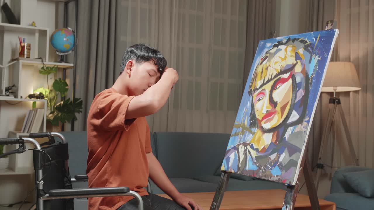 Asian Artist Boy In Wheelchair Holding Paintbrush Mixed Colour Turn To Cross His Arms And Smile While Painting A Girl On The Canvas