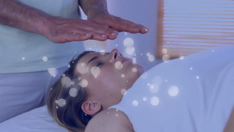 animation of dots moving over hands of caucasian man doing massage to female customer