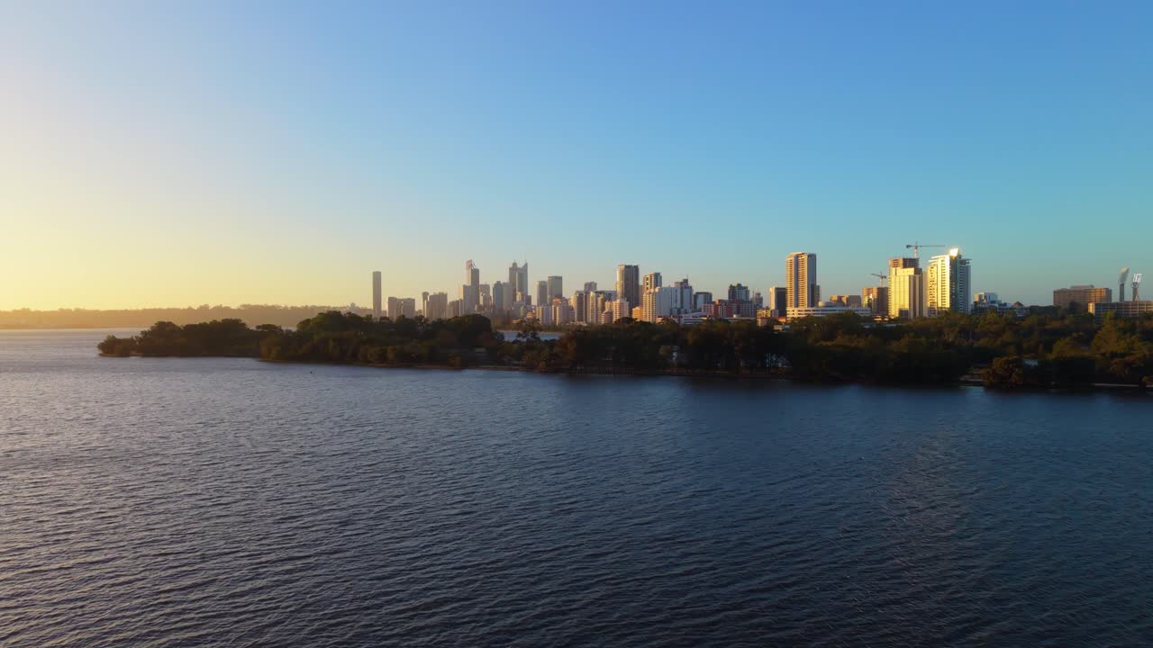 Voo cinematográfico de drone sobre o Rio Swan em Perth, com reflexos da cidade na água