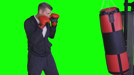 hombre caucásico golpeando una bolsa de boxeo en el estudio