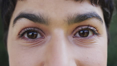 los ojos de una mujer caucásica feliz sonriendo en un jardín soleado, en cámara lenta.