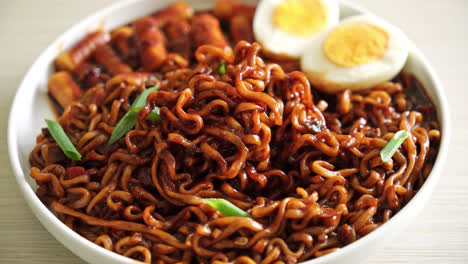 jjajang rabokki - korean instant noodles or ramyeon with korean rice cake or tteokbokki and egg in black bean sauce - korean food style