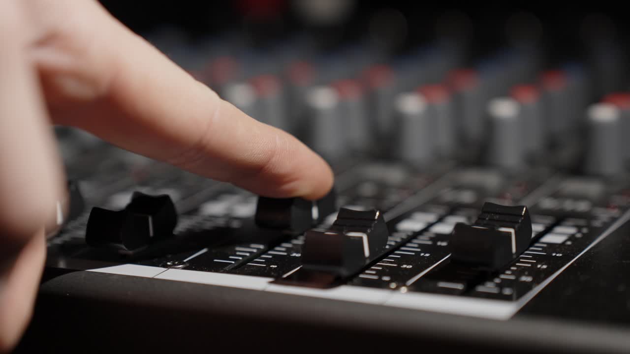 finessing diales de ecualizador en el estudio de mezcla de sonido
