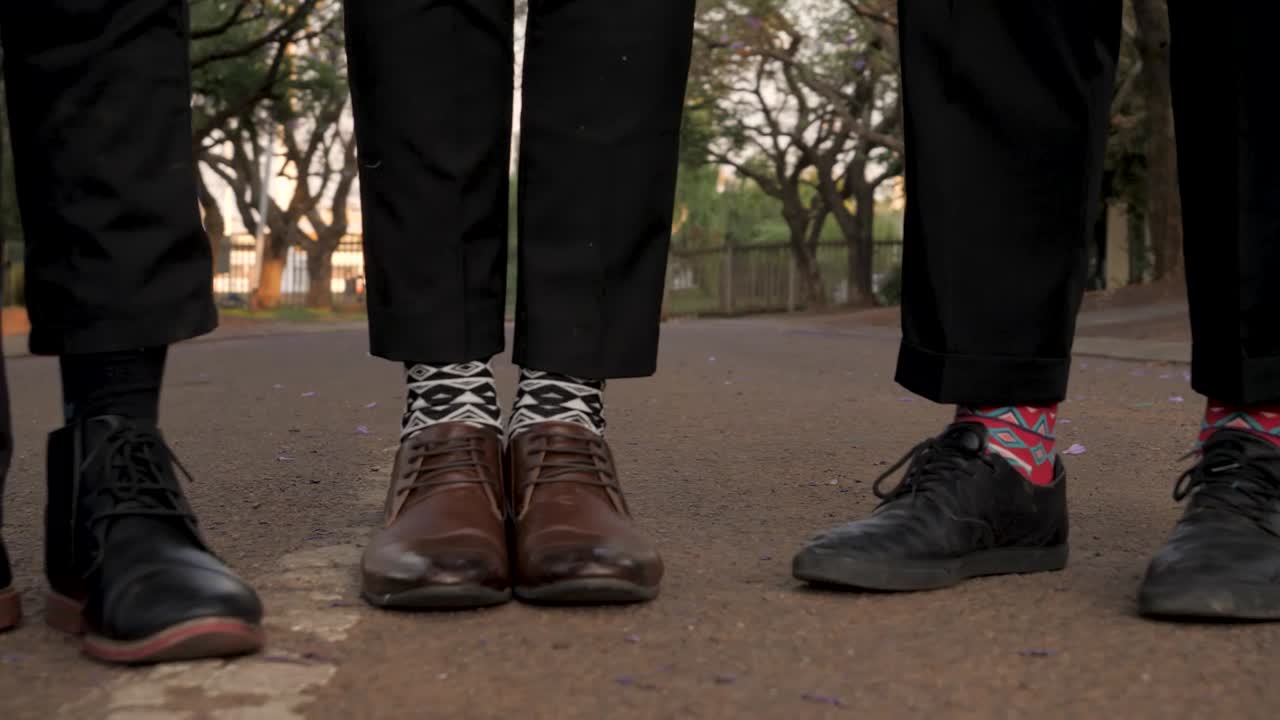 Several men's dress shoes and fun socks on the street