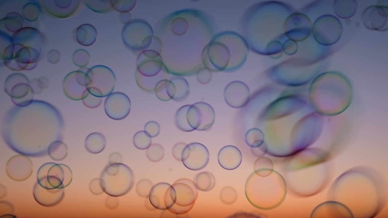 Soap bubbles on sky at sunset summer slow motion. Bright background multicolored bubbles smoothly fly in sky. Childhood, Freedom. Dreams. Relax. Happiness