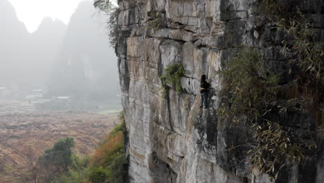 female rock climber ascending the egg rock face, yangshuo china, 4k aerial view