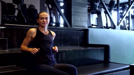 a fit girl turns on a second hand watch for sports exercises on a wristwatch