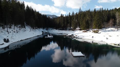 Icy-Cold-Waters-Of-Lake-Caumasee-With-Coniferous-Forest-On-A-Sunny-Winter-Day-In-Switzerland