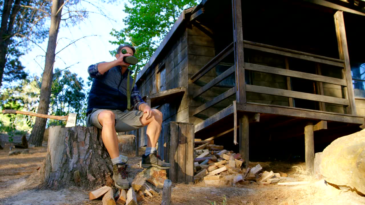 Male logger drinking water in the forest 4k