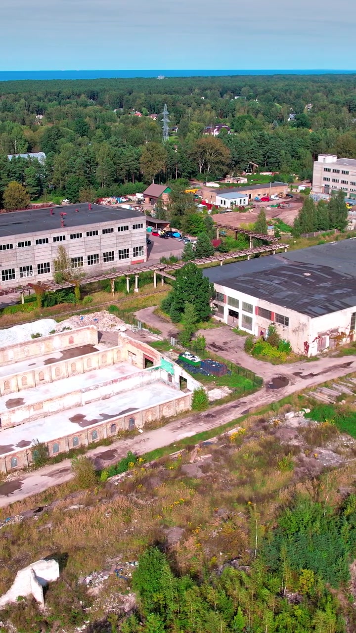 Letonya’da ağaçlarla çevrili, terk edilmiş bir sanayi bölgesinin havadan görünümü