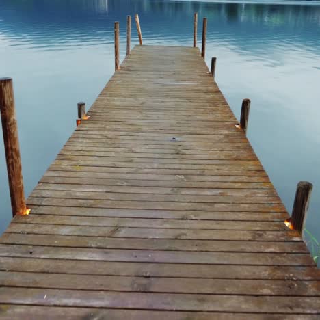 toma de steadicam: antiguo muelle de madera en un pintoresco lago de montaña en los alpes en austria 2
