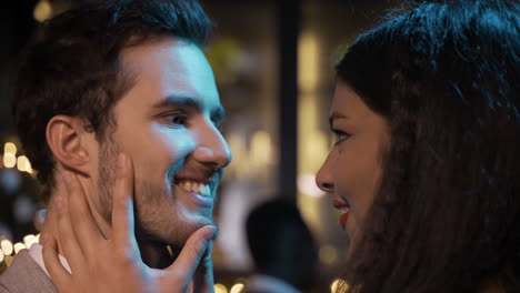 close up view of a couple celebrating new year's eve party, they get closer and kiss while smiling 1