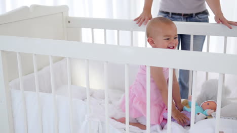 woman putting her baby girl in a cradle