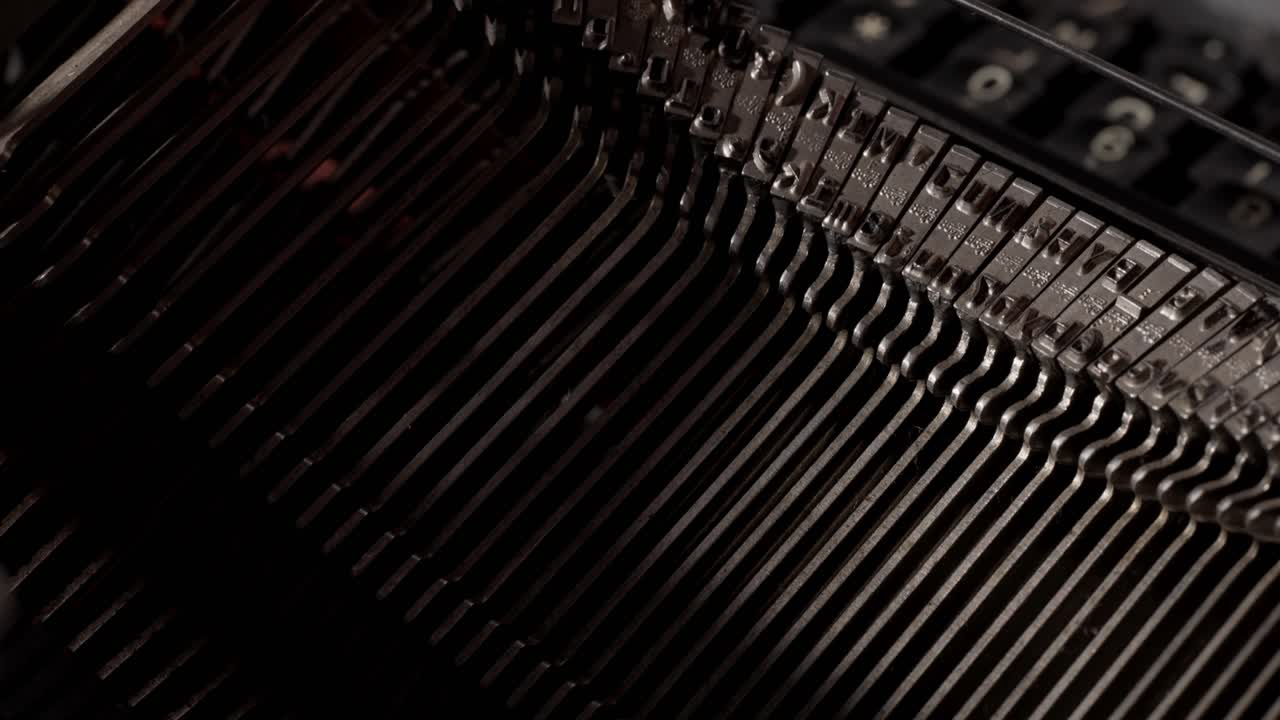 Detailed close-ups reveal the inner workings of a typewriter as it types words on paper