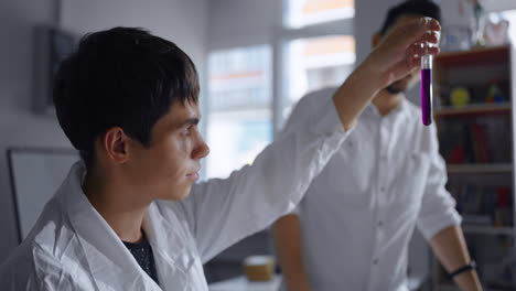 a young student performs a chemistry experiment in a lab.