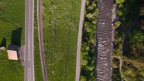 Imágenes-Aéreas-De-Drones-Vista-De-Arriba-Hacia-Abajo-De-La-Carretera,-El-Ferrocarril-Y-Un-Río-Cerca-De-Grindelwald-En-Los-Alpes-Suizos