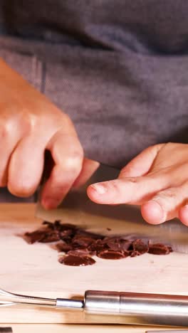 persona cortando discos de chocolate con un cuchillo