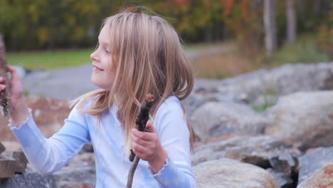 adorable blonde girl having fun time outside and smiling, front view