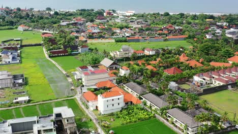 tropical-skyline-of-Berawa-Bali-on-sunny-day-with-ocean-coastline-in-distance,-aerial