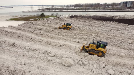 bulldozers en el trabajo en el vertedero de nieve, tratando de reducir la gran cantidad de nieve arrastrada causada por una tormenta de nieve extrema en buffalo, nueva york, ee.uu.