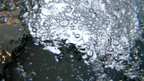 Under-water-oxygenbubbles-floating-on-surface-in-pool,-Close-up