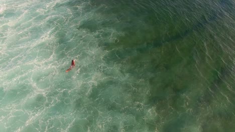 surfer duck diving under turquoise wave