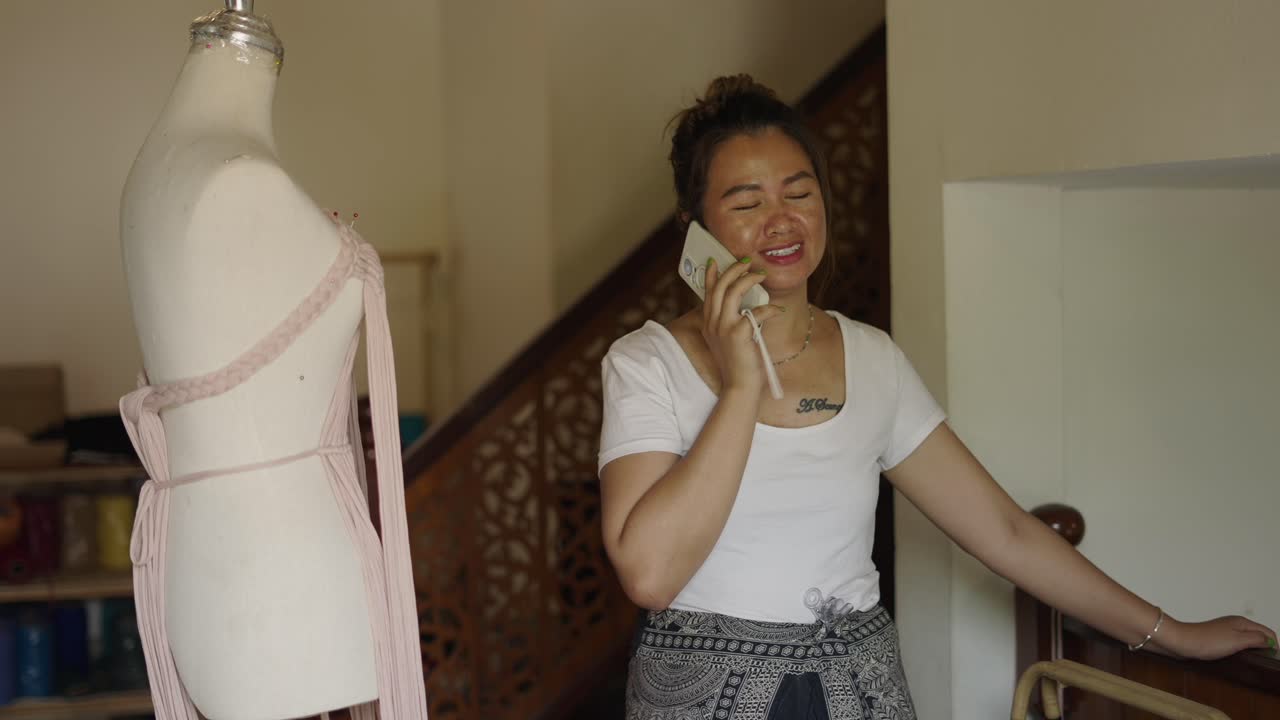Woman talking on the phone next to a fashion mannequin in a home studio