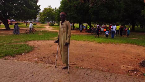 disabled man with crutches in a park with people