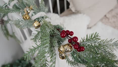 frosted pine decoration with golden bells and red berries