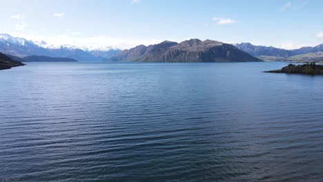 sweeping panoramic shot capturing the vast expanse of lake wanaka, showcasing its crystal-clear blue waters and the surrounding mountains