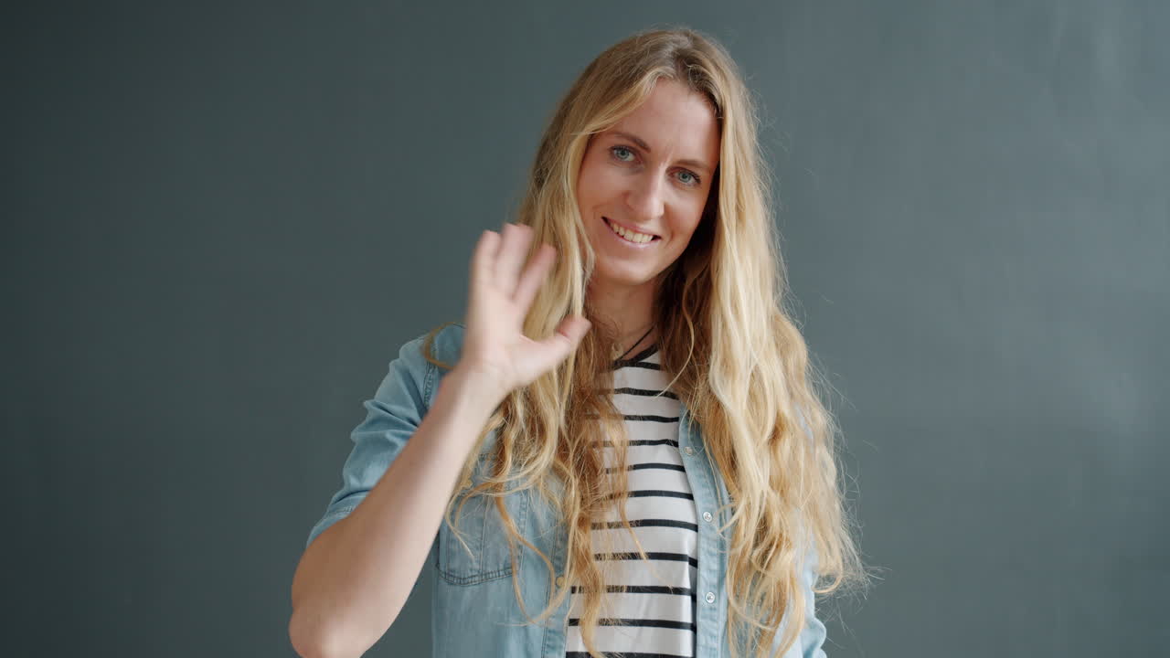 una mujer saludando.