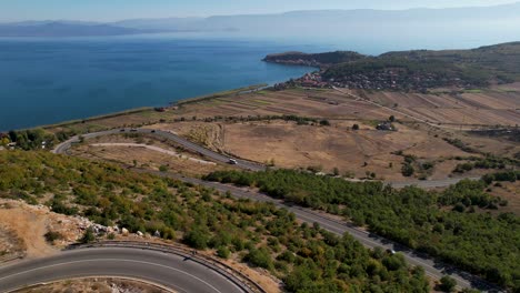 Concepto-De-Viaje-Camino-Curvo-Con-Autos-Conduciendo-En-Una-Zona-Montañosa-Cerca-De-Un-Hermoso-Lago-En-Albania