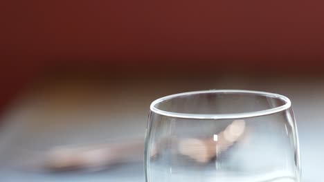 Picking-up-Empty-Drinking-Glasses-from-a-Table-Close-Up-with-Hands,-Stemless-Wine-Glasses-in-a-Restaurant-for-Fine-Dining