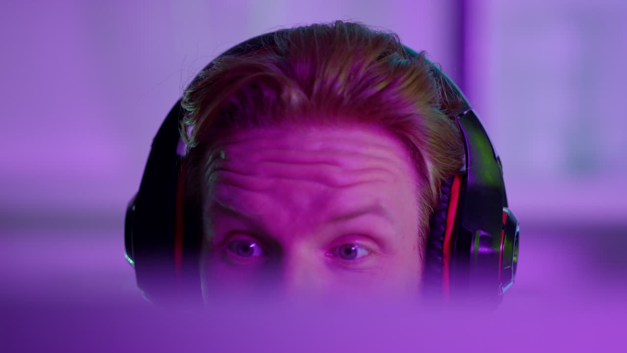 jugador celebrando el éxito cibernético en la sala de neón. hombre feliz jugando juegos de computadora