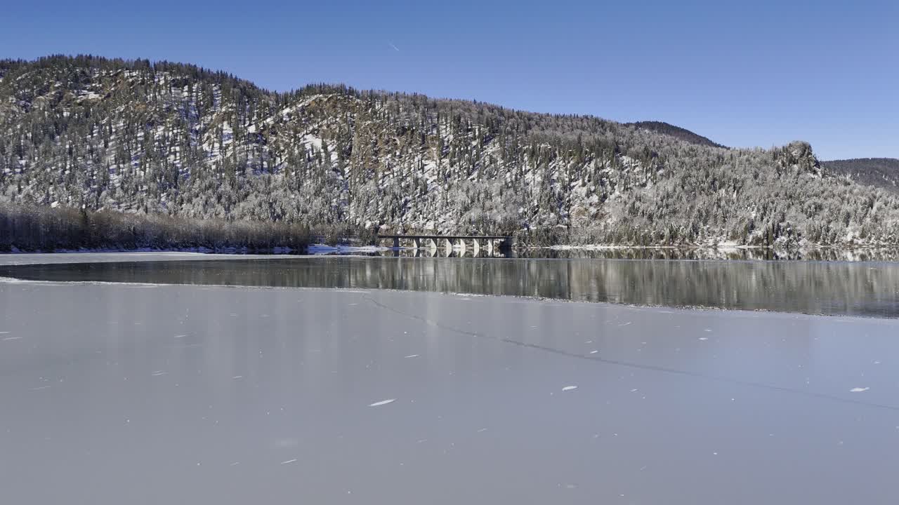 Flight over frozen reservoir in the Alps Bavaria.