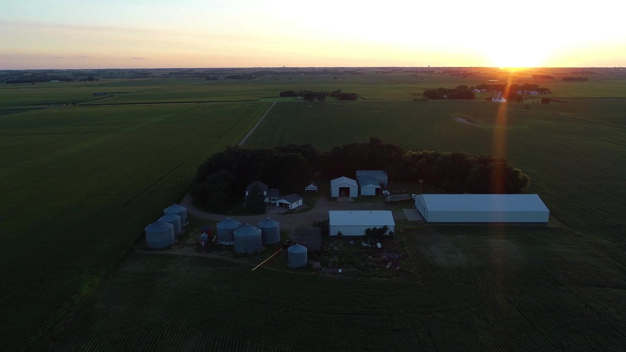 Flyver over en gård ved solnedgang i 4K