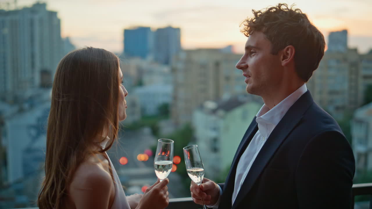 Lovely couple clinking champagne standing restaurant terrace at twilight closeup