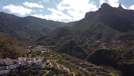 Aerial-drone-view-of-Tejeda-town-amidst-mountains-against-Roque-Nublo-and-Bentayga-in-Gran-Canaria-Spain