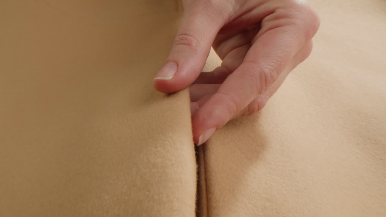 Primo piano di un tessuto beige con una mano