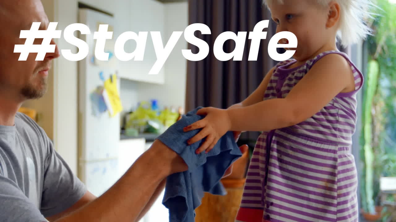 Animation of stay safe text over father and daughter at home