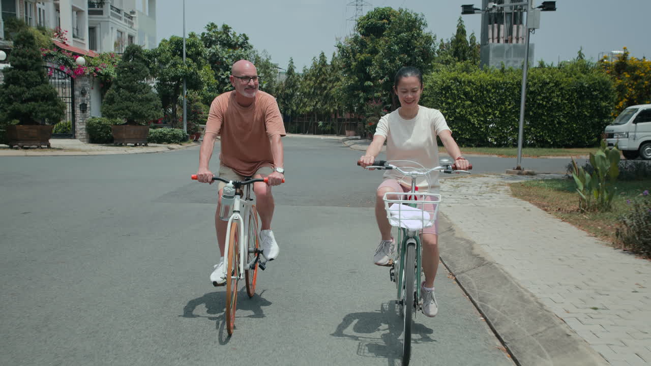 Bi-ethnic Spouses Cycling and Talking Outdoors
