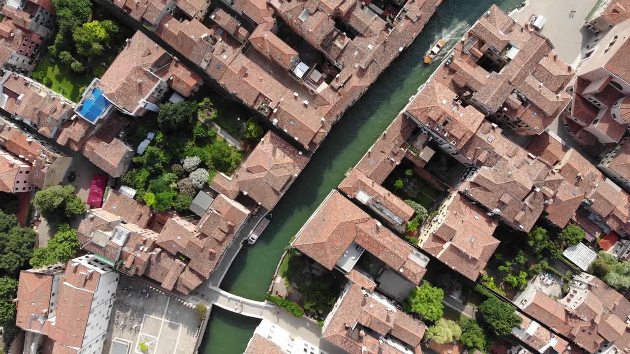 Una vista aerea con drone di un taxi acqueo, un ponte in stile veneziano e turisti a Venezia, Italia