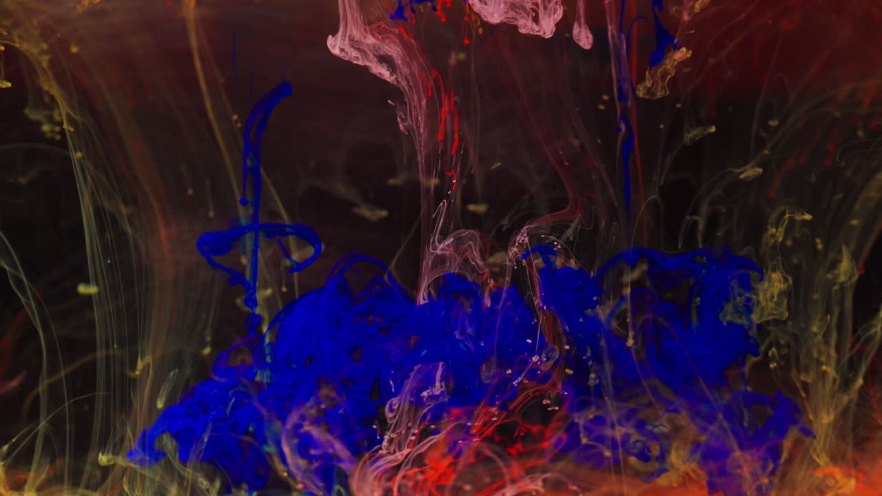 Colorful ink swirling underwater in a calming, artistic macro shot